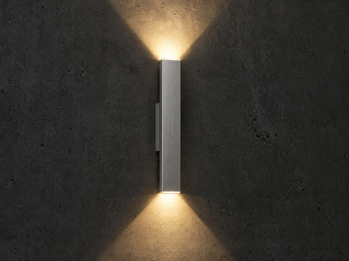 Applique murale LED en aluminium éclairant vers le haut et vers le bas sur un mur sombre